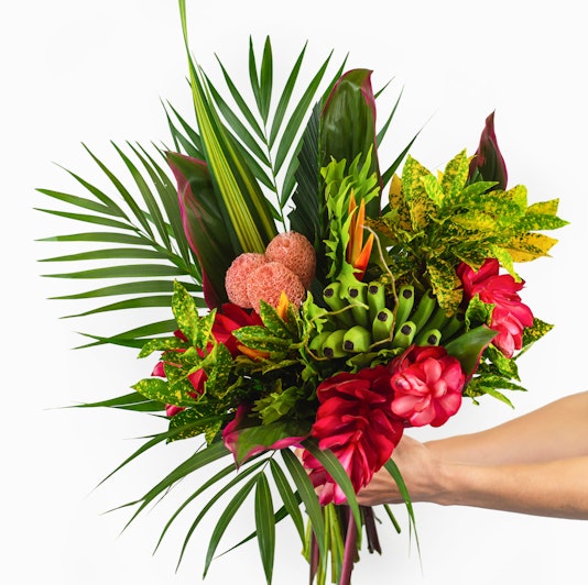 Vibrant tropical bouquet featuring lush greens, red flowers, and unique textures for any occasion.
