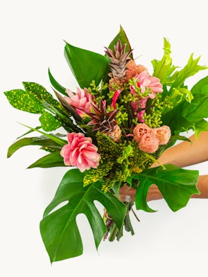 Vibrant tropical bouquet featuring pink flowers and lush green foliage, perfect for celebrations.