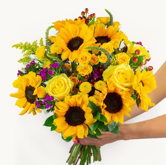 Vibrant bouquet of sunflowers, roses, and colorful blooms, perfect for cheerful occasions.