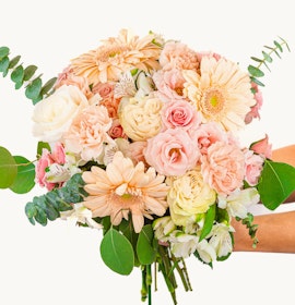 A lovely pastel bouquet featuring roses, gerbera daisies, and lush greenery.