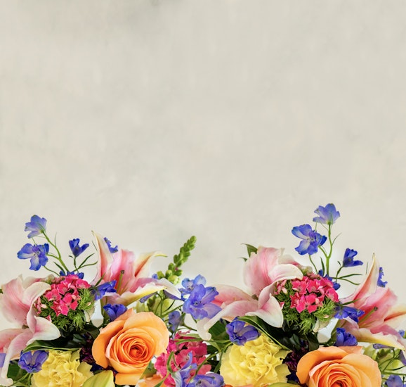 Vibrant floral arrangement featuring lilies, roses, and colorful blooms in a lush display.