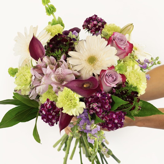 Vibrant mixed flower bouquet featuring roses, lilies, and daisies in a stunning arrangement.