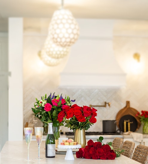 Elegant floral arrangements of roses and vibrant blooms on a kitchen counter, ready for celebration.