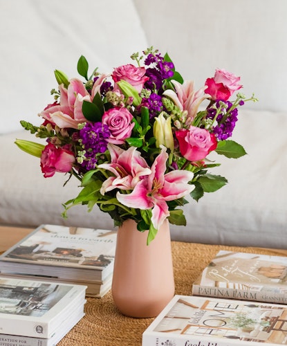 Vibrant floral arrangement featuring pink roses and lilies in a chic vase, enhancing home decor.