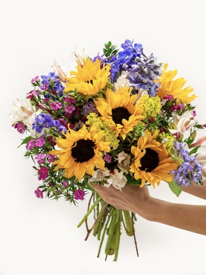 Bright sunflower bouquet featuring purple and pink blooms, perfect for cheerful occasions.